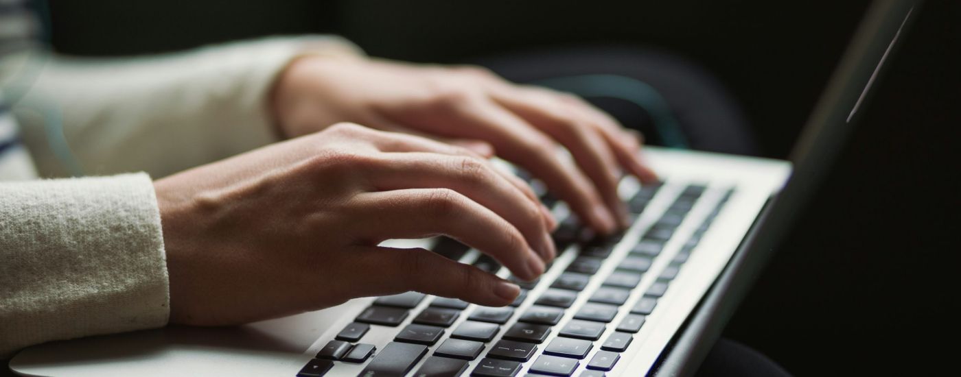 person typing  at a laptop